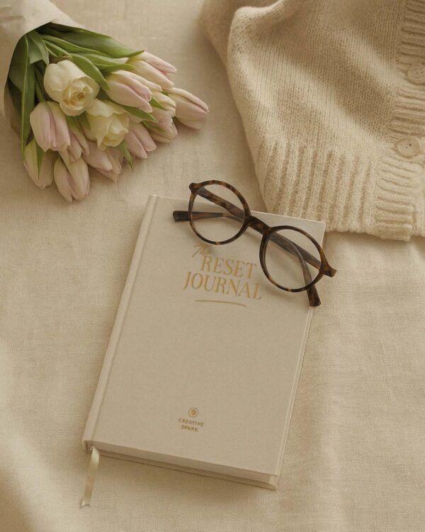 la couverture en lin sable du reset journal, posé sur une nappe en lin beige. Ecrit par Manifa Kind aux éditions Creative spark